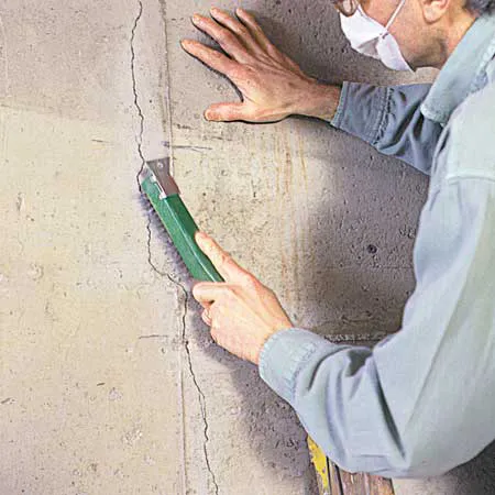 Scrub the crack clean of any loose concrete, paint or old crack filler using a wire brush.